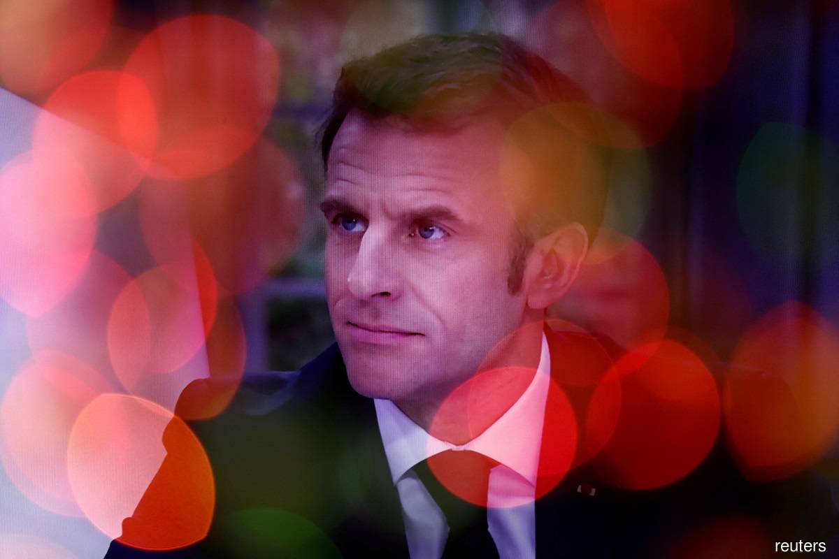 French President Emmanuel Macron is seen on a screen as he speaks during an interview on national television in Paris March 22, 2023. (Reuters pic)